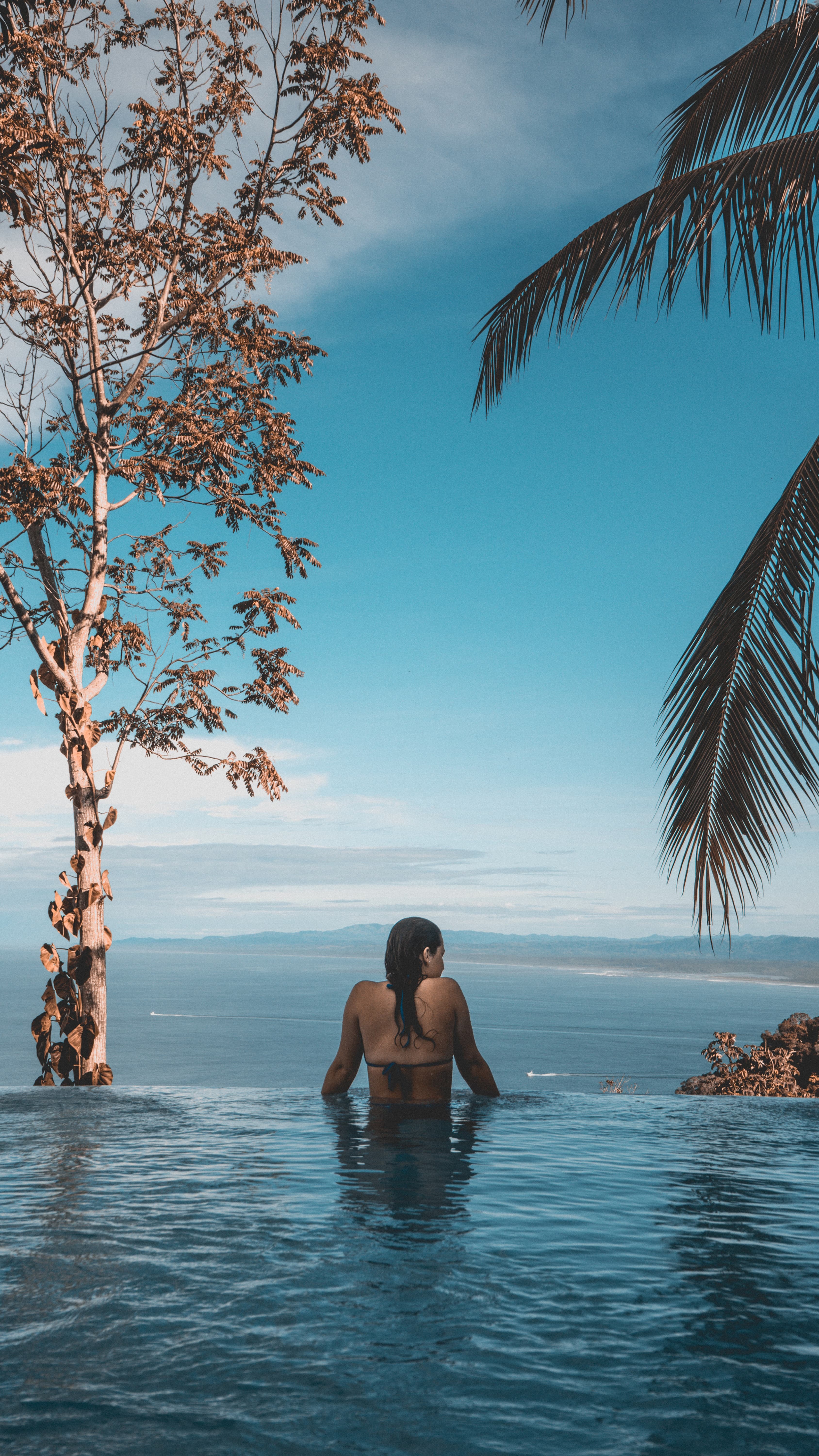 Verra creative strategy services — woman in infinity pool with palm trees